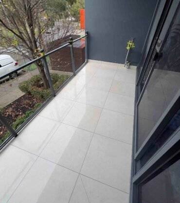 Professional-bathroom-tiler-installing-outdoor-floor-tiles-on-Melbourne-balcony