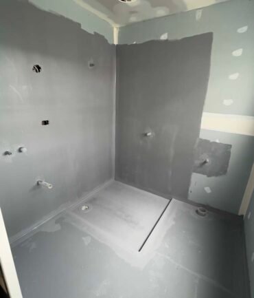 applying waterproofing primer with brush bathroom shower melbourne construction