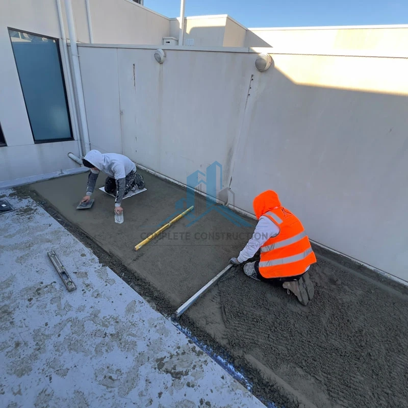 Workers screeding a balcony during leak repair services in Melbourne