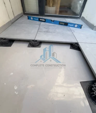 Balcony pavers installed over adjustable pedestal supports